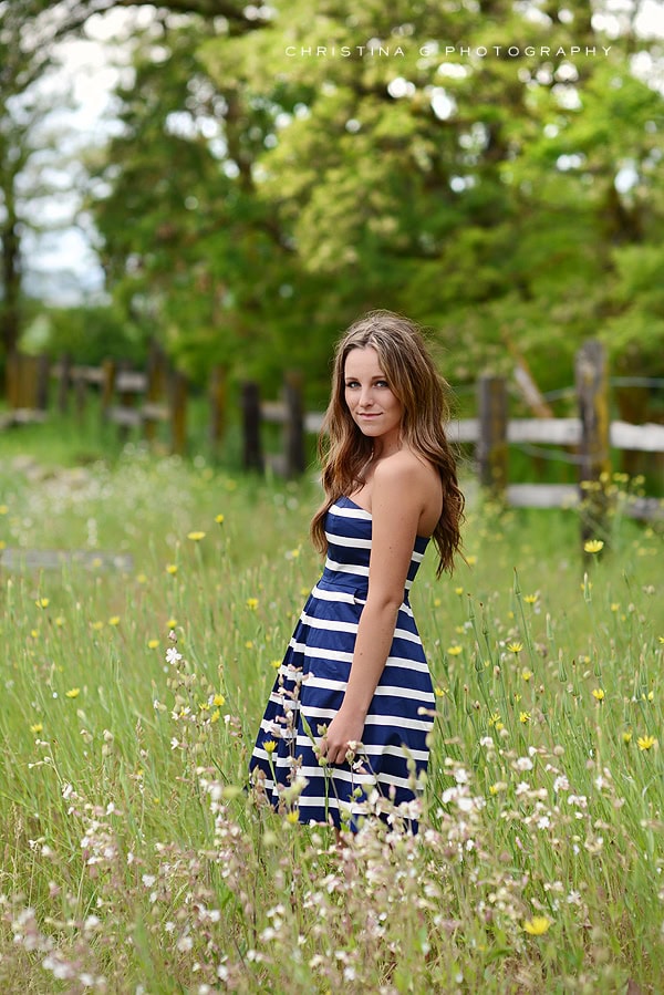 PRETTY TEEN GIRL IN FIELD OF FLOWERS WITH BLUE AND WHITE DRESS