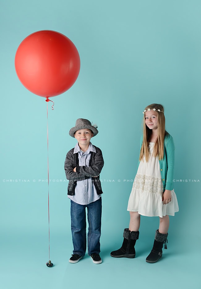 BOY AND GIRL IN STUDIO IN FRONT OF TURQUOISE BACKDROP