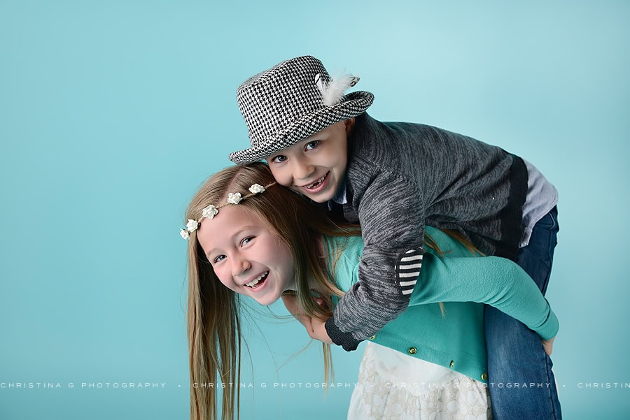 BOY AND GIRL IN STUDIO IN FRONT OF TURQUOISE BACKDROP